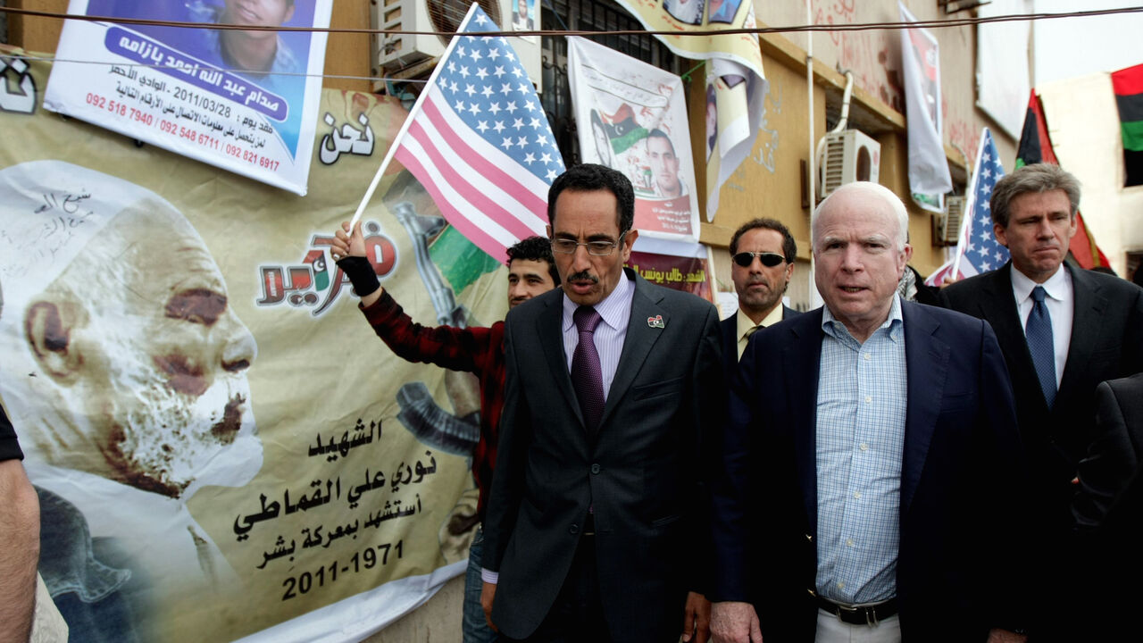 Nic568659 US Rebuplican senator John McCain (R) walks with Abdul Hafiz Ghoqa, spokesman of the Libyan National Transitional Council (NTC), during his tour to the rebel headquarters in their eastern stronghold city of Benghazi on April 22, 2011. McCain is the highest-ranking US politician to visit Libya's rebel-held east since a popular uprising began against Moamer Kadhafi's rule in mid-February. AFP PHOTO/MARWAN NAAMANI (Photo credit should read MARWAN NAAMANI/AFP/Getty Images)