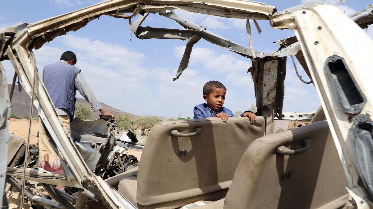 YEMEN-SECURITY/CHILDREN Hafidh Abdullah al-Khawlani, who survived a Saudi-led air strike stands with his father on the wreckage of a bus destroyed by the strike in Saada, Yemen September 4, 2018. His brother was killed by the air strike. Picture taken September 4, 2018. REUTERS/Naif Rahma - RC1FB49D40C0