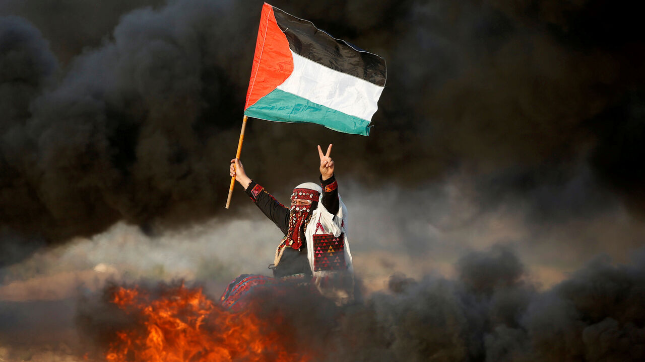 Woman waves a Palestinian flag during a protest at the Israel-Gaza border fence east of Gaza City A woman waves a Palestinian flag during a protest calling for lifting the Israeli blockade on Gaza and demanding the right to return to their homeland, at the Israel-Gaza border fence east of Gaza City September 28, 2018. REUTERS/Mohammed Salem TPX IMAGES OF THE DAY - RC18D059CEE0