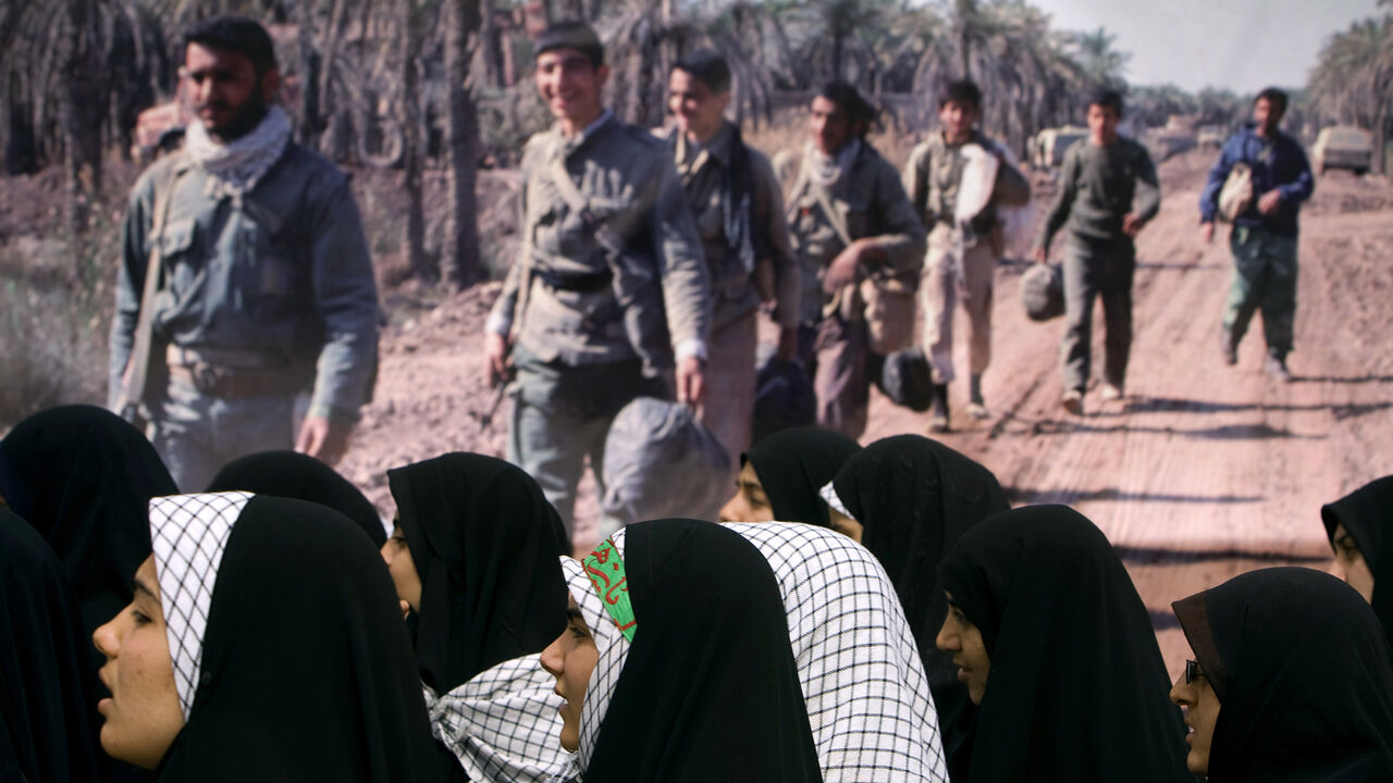 IRAN/ Women stand next to a picture of war veterans as they visit a war memorial site in Khoozestan province near the Iraqi border, 1,345 km (841 miles) southwest of Tehran, March 19, 2009. Iranians visit the main battlegrounds of the Iran-Iraq war (1980-88) during the last week of the Iranian calendar to remember martyrs who died in the war. REUTERS/Morteza Nikoubazl (IRAN ANNIVERSARY CONFLICT POLITICS) - GM1E53J1LIZ01