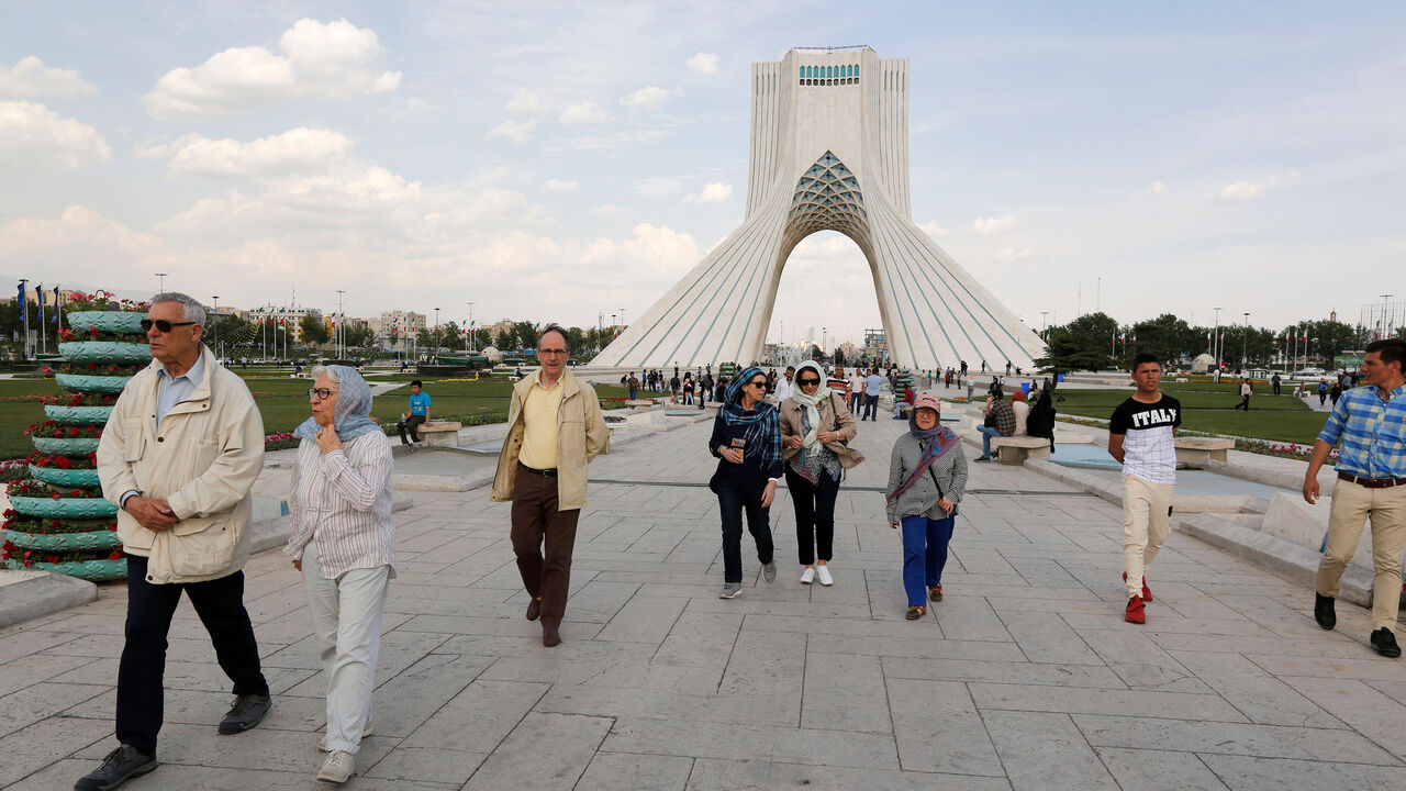 AFP_14H7WS Tourists visit the Azadi Tower in the capital Tehran on April 19, 2018. - On April 15, the central bank banned foreign exchange bureaus "until further notice" from buying or selling foreign currency, leaving banks alone to carry out such transactions. But in practice, they refuse to do so, according to numerous testimonies. (Photo by ATTA KENARE / AFP) (Photo credit should read ATTA KENARE/AFP/Getty Images)