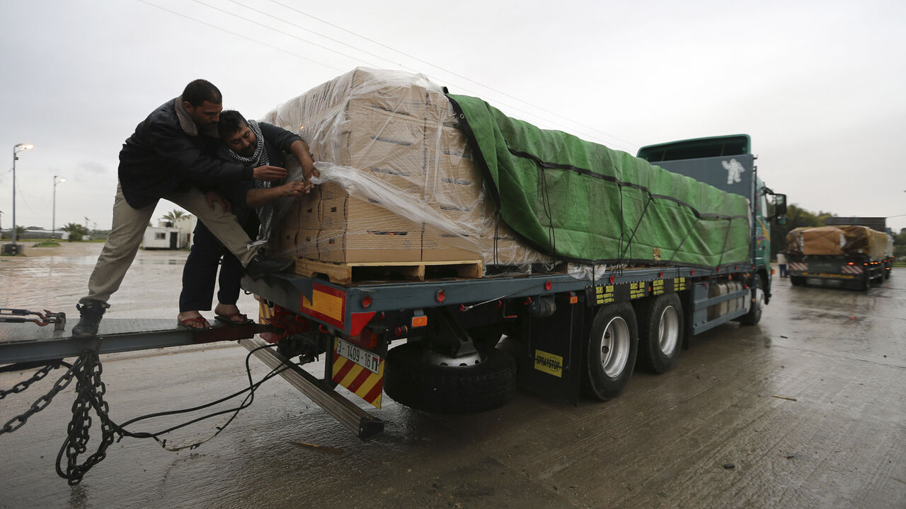 ISRAEL-PALESTINIANS/EXPORTS Palestinians cover cartons containing vegetables before exporting them to Israel, at the Kerem Shalom crossing in Rafah in the southern Gaza Strip March 12, 2015. Israel imported its first fruit and vegetables from the Gaza Strip in almost eight years on Thursday, in a partial easing of an economic blockade maintained since the Islamist group Hamas seized control of the Palestinian territory. Twenty-seven tonnes of tomatoes and five tonnes of eggplants were trucked across the border under an Israeli plan t