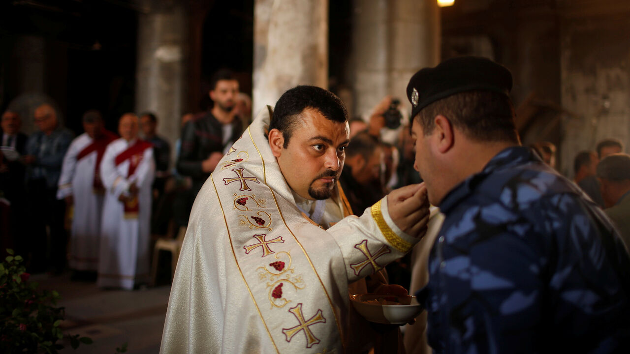 MIDEAST-CRISIS/IRAQ-MOSUL-CHRISTIANS Iraqis attend the first Palm Sunday procession in the burnt out main church of the Christian city of Qaraqosh since Iraqi forces retook it from Islamic States militants, Iraq April 9, 2017. REUTERS/Suhaib Salem - RC1D40BC7F70