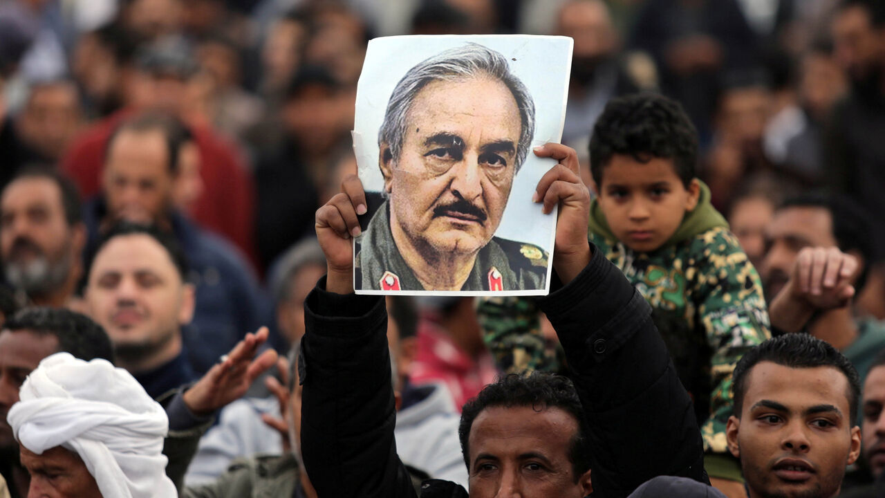 LIBYA-SECURITY/ A man holds a poster of Eastern Libyan military commander Khalifa Haftar during a rally demanding Haftar to take over, after a U.N. deal for a political solution missed what his supporters said was a self-imposed deadline on Sunday, in Benghazi, Libya, December 17, 2017. REUTERS/Esam Omran Al-Fetori - RC1E8C45E420