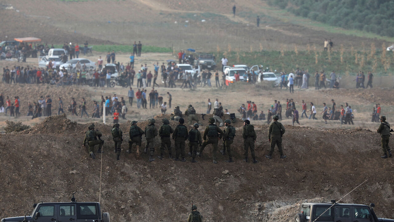 ISRAEL-PALESTINIANS/PROTESTS Israeli soldiers are seen next to the border fence on the Israeli side of the Israel-Gaza border as Palestinians protest on the Gaza side of the border, Israel October 19, 2018 REUTERS/Amir Cohen - RC16D6B86910
