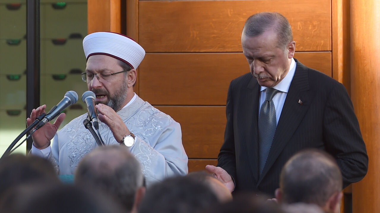 AFP_19L5NY Turkish President Recep Tayyip Erdogan (R) and Imam Ali Erbas pray to officially open the newly built DITIB central mosque in Cologne, western Germany, on September 29, 2018. - The inauguration will be the closing event of the three-day state visit of Turkish President Recep Tayyip Erdogan, aimed at repairing frayed ties with Berlin after two years of tensions. (Photo by PATRIK STOLLARZ / AFP) (Photo credit should read PATRIK STOLLARZ/AFP/Getty Images)