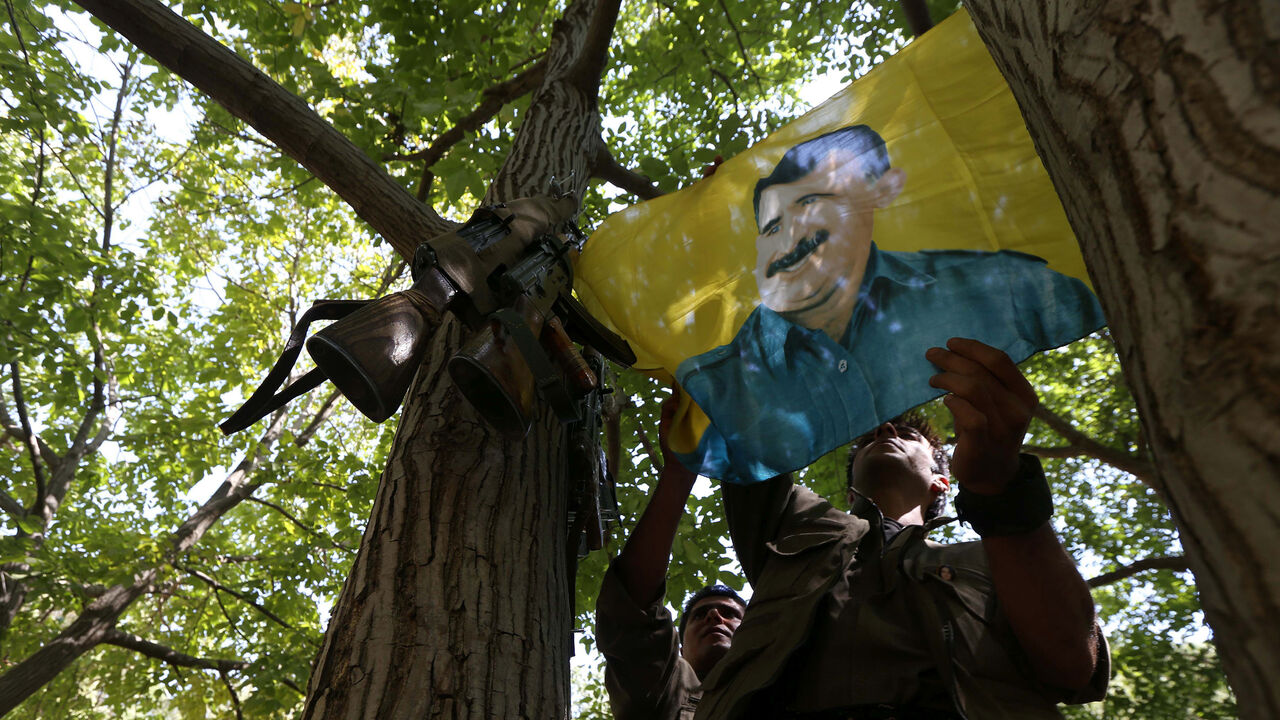 AFP_RX1TC A member of the anti-Iranian group, Kurdistan Free Life Party (PJAK), hangs up a flag of jailed Kurdistan Workers' Party (PKK) leader, Abdullah Ocalan, at their base deep on the Iraq-Iran border of northern Iraq's Kurdish autonomous region, on August 28, 2017. / AFP PHOTO / SAFIN HAMED (Photo credit should read SAFIN HAMED/AFP/Getty Images)