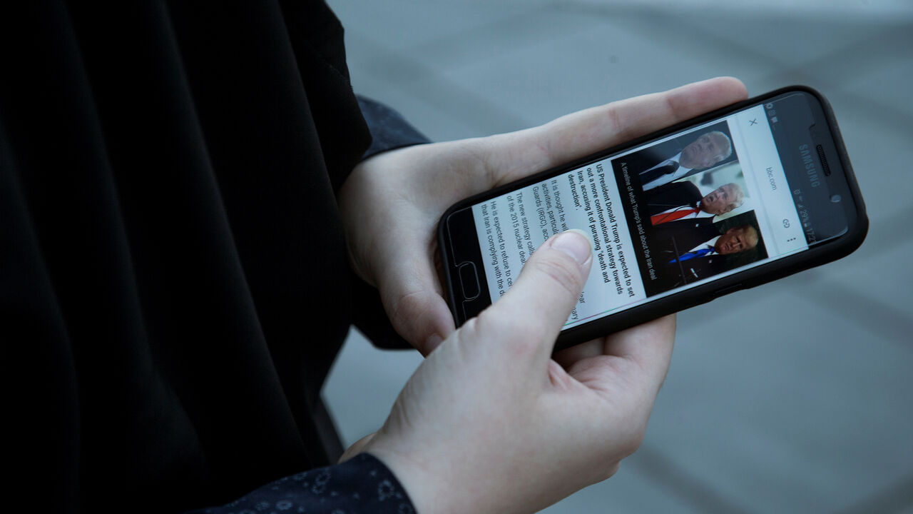 IRAN-NUCLEAR/ A woman displays pictures of U.S. President Donald Trump as she follows the news on her mobile phone in Tehran, Iran October 13, 2017. Nazanin Tabatabaee Yazdi/TIMA via REUTERS ATTENTION EDITORS - THIS IMAGE WAS PROVIDED BY A THIRD PARTY. - RC199832B120