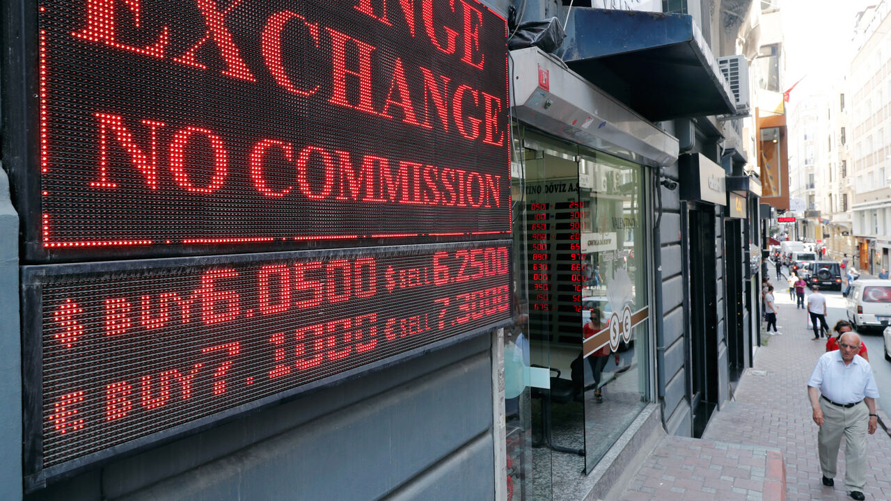 TURKEY-CURRENCY/ A man walks past by a board showing the currency exchange rates next to a currency exchange office in Istanbul, Turkey August 28, 2018. REUTERS/Osman Orsal - RC133EF73130