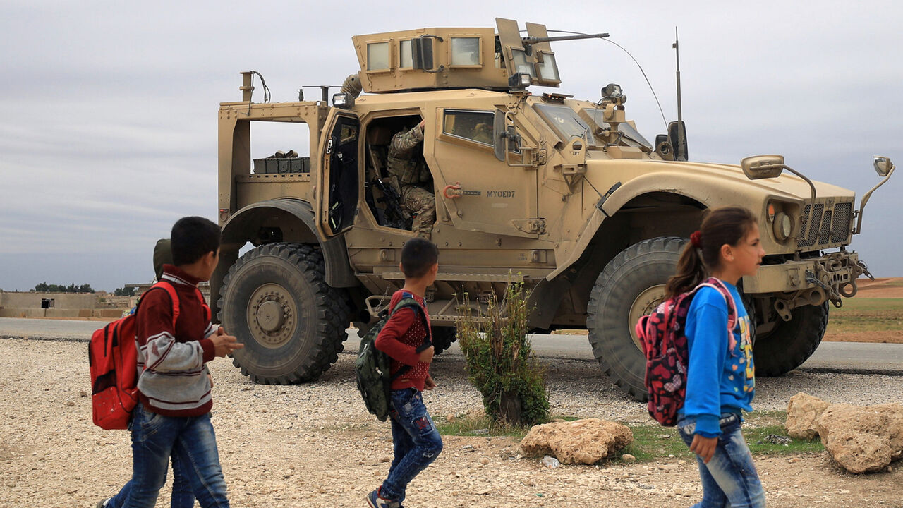 MIDEAST-CRISIS/SYRIA-TURKEY Syrian schoolchildren walk as U.S. troops patrol near Turkish border in Hasakah, Syria November 4, 2018. REUTERS/Rodi Said - RC11C2532E70
