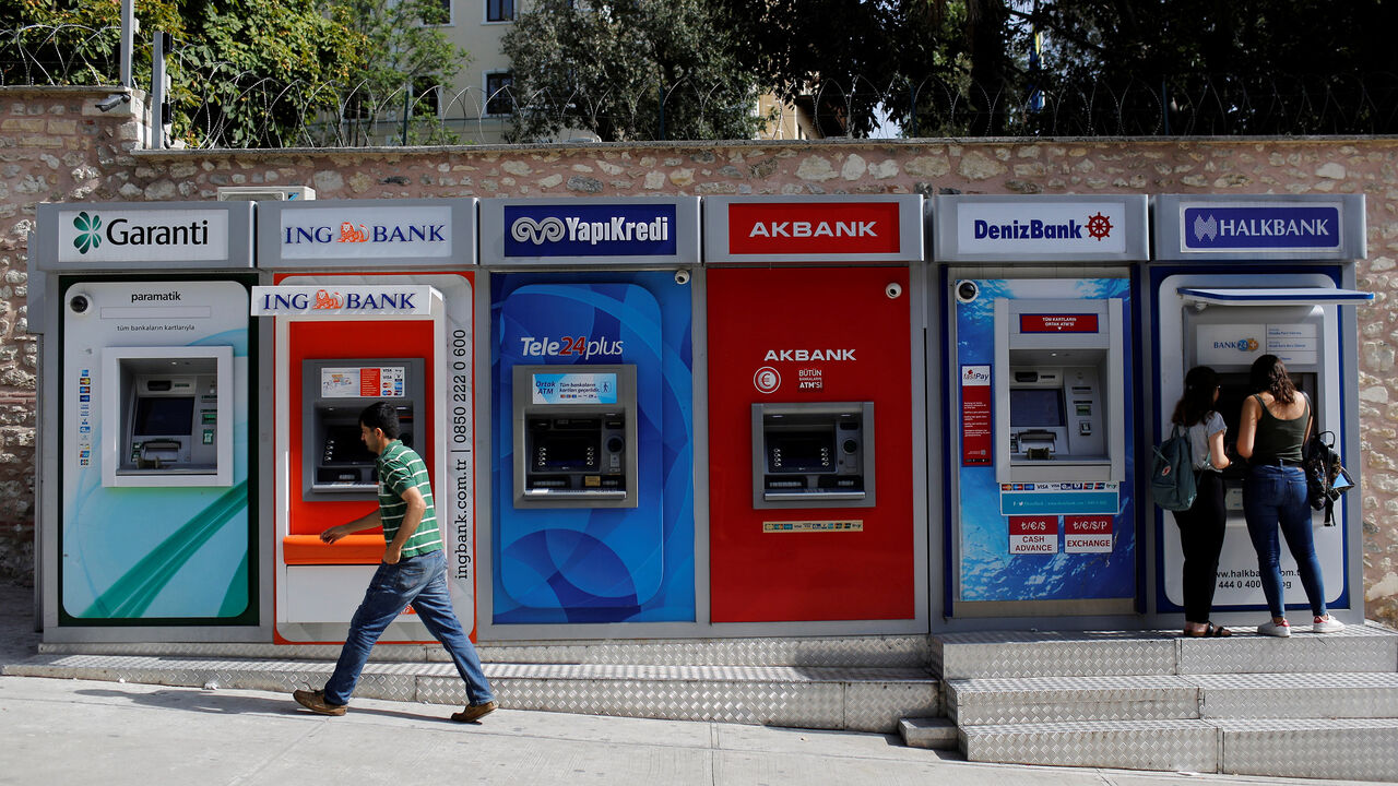 GLOBAL-BANKS/ Women withdraw cash from an ATM of Halkbank in Istanbul, Turkey, September 12, 2017. REUTERS/Murad Sezer - RC1806970730