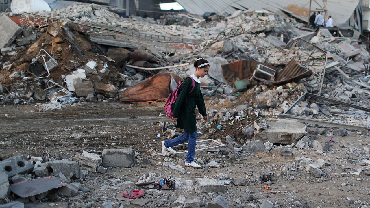 ISRAEL-PALESTINIANS/ A Palestinian schoolgirl walks past the scene of an Israeli air strike on a building in Gaza City October 27, 2018. REUTERS/Mohammed Salem - RC1879C7A810