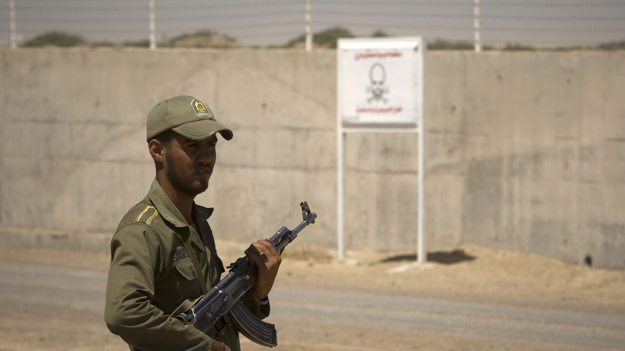 DRUGS-UN/IRAN An Iranian anti-narcotics policeman stands guard beside the border barrier with Afghanistan near Zabol, 1,605 kilometers (1,003 miles) southeast of Tehran May 20, 2009. Iran, which shares a 900-km (560-mile) border with Afghanistan, is a conduit for smuggling drugs to the West from its insurgency-ridden neighbour. REUTERS/Caren Firouz (IRAN CRIME LAW POLITICS SOCIETY) - GM1E55L1EMR01