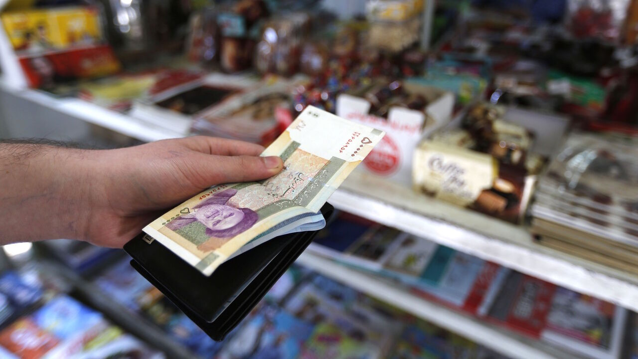 AFP_181563 A man holds a stack of Iranian Rials in front of a shop in the capital Tehran on July 31, 2018. - Iran's currency traded at a fresh record-low of 119,000 to the dollar on today, a loss of nearly two-thirds of its value since the start of the year as US sanctions loom. (Photo by ATTA KENARE / AFP) (Photo credit should read ATTA KENARE/AFP/Getty Images)
