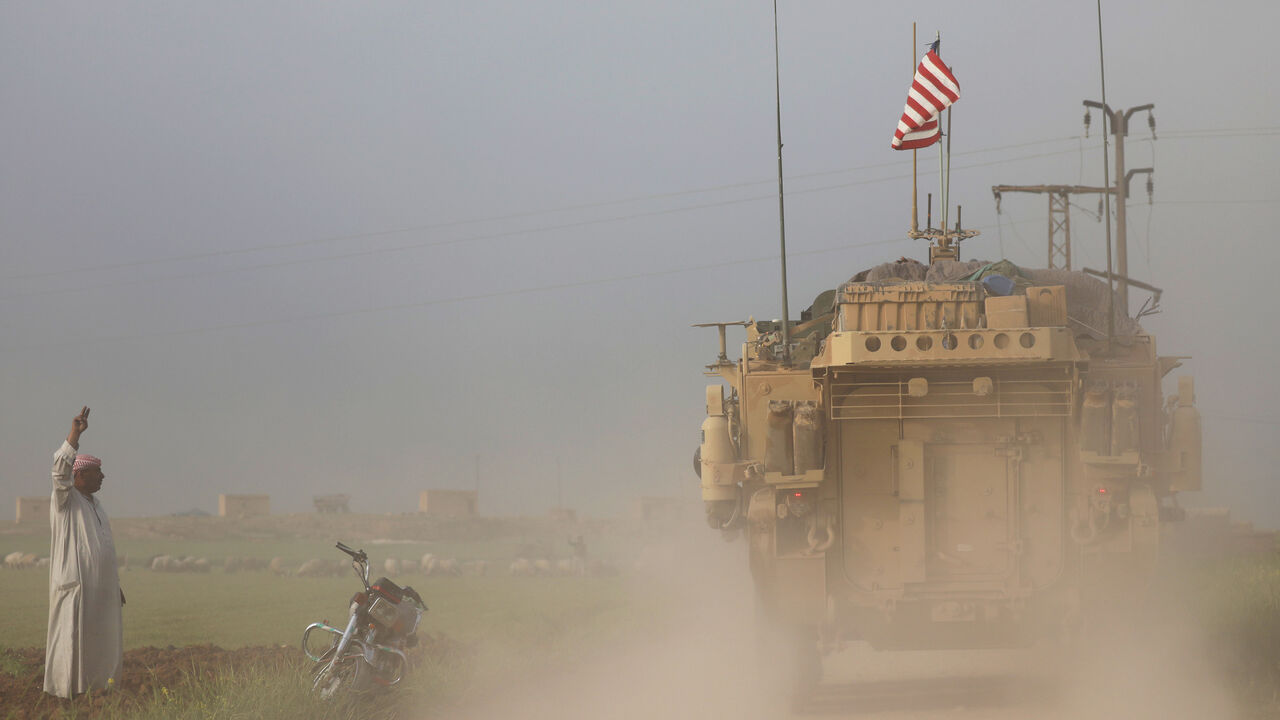 MIDEAST-CRISIS/SYRIA-KURDS A man gestures at U.S military vehicles driving in the town of Darbasiya next to the Turkish border, Syria April 28, 2017. REUTERS/Rodi Said TPX IMAGES OF THE DAY - RC15AC3FC730