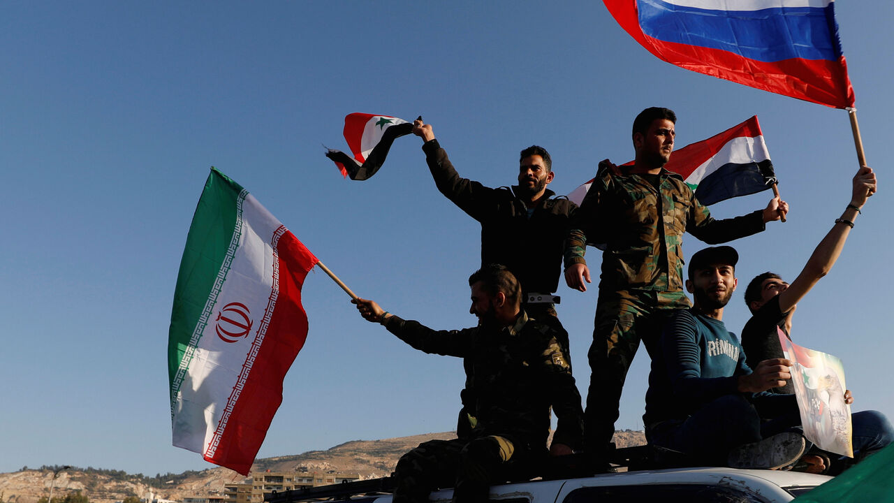 MIDEAST-CRISIS/SYRIA Syrians wave Iranian, Russian and Syrian flags during a protest against U.S.-led air strikes in Damascus,Syria April 14,2018.REUTERS/ Omar Sanadiki TPX IMAGES OF THE DAY - RC1815671B90