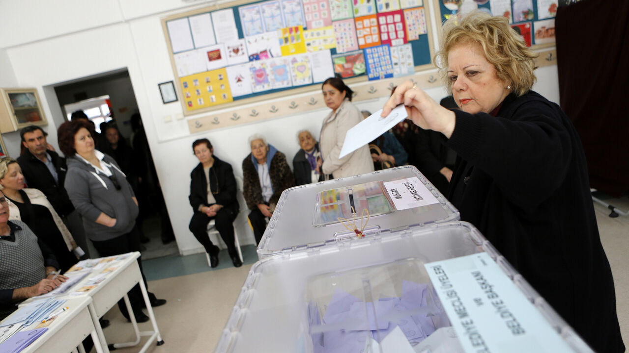 TURKEY-ELECTION/ A woman casts her vote as others wait in line at a polling station in Ankara March 30, 2014. Prime Minister Tayyip Erdogan looks set to win Sunday's municipal elections that have become a crisis referendum on his 10-year rule as he tries to ward off graft allegations and stem a stream of damaging security leaks. REUTERS/Umit Bektas (TURKEY - Tags: POLITICS ELECTIONS) - GM1EA3U1L4001