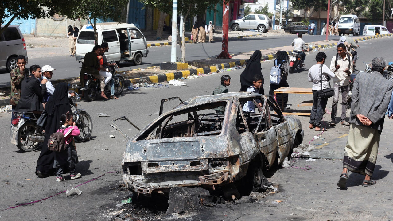 YEMEN-SECURITY/ Onlookers look at a car burnt down by a blast in the war-torn southwestern city of Taiz, Yemen January 22, 2019. REUTERS/Anees Mahyoub - RC1FAD2F1FA0