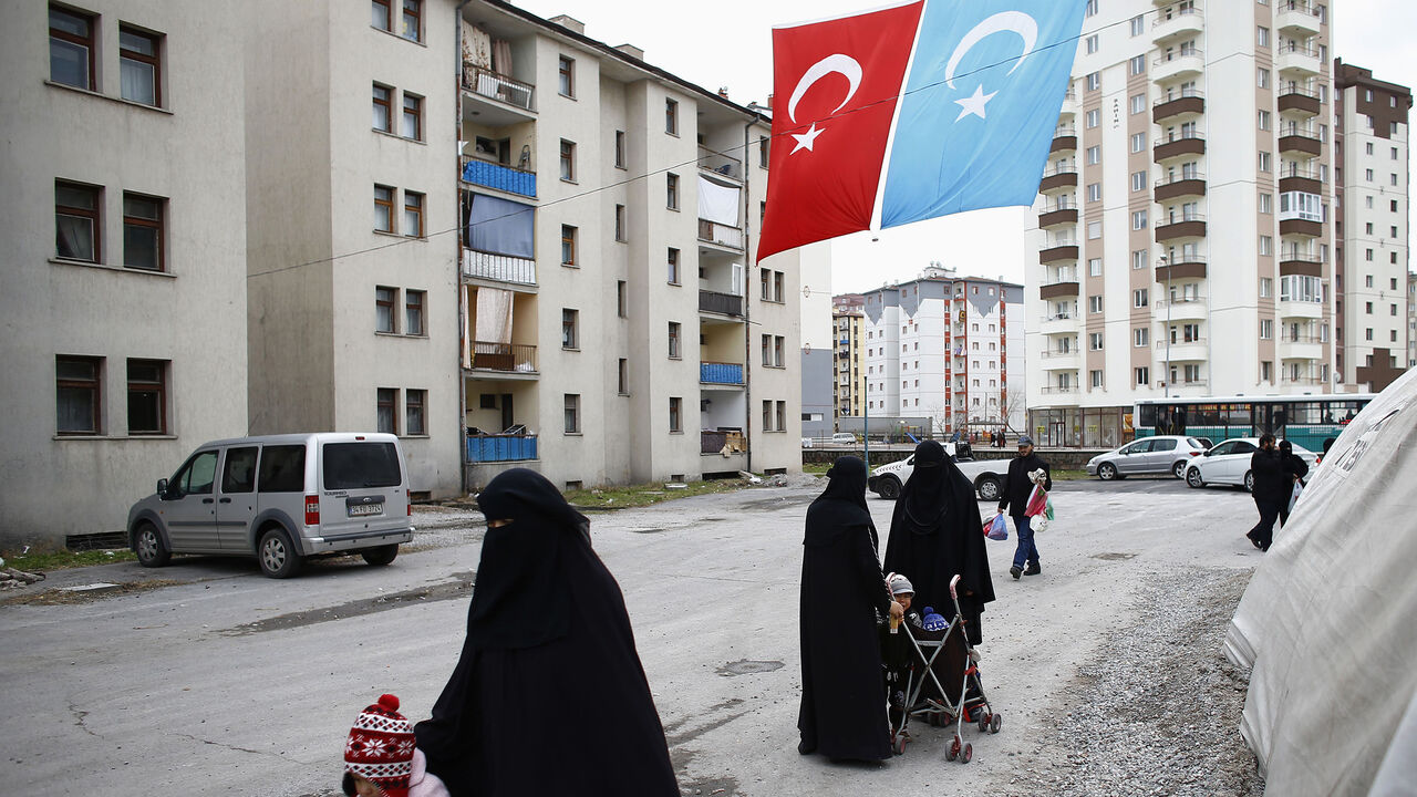 TURKEY-CHINA/UIGHURS Uighur refugee women walk where they are housed in a gated complex in the central city of Kayseri, Turkey, February 11, 2015. Thousands of members of China's Turkic language-speaking Muslim ethnic minority have reached Turkey, mostly since last year, infuriating Beijing, which accuses Ankara of helping its citizens flee unlawfully. Turkish officials deny playing any direct role in assisting the flight. Picture taken February 11, 2015. To match Insight TURKEY-CHINA/UIGHURS REUTERS/Umit Bektas - GM1EB7R1LSD01