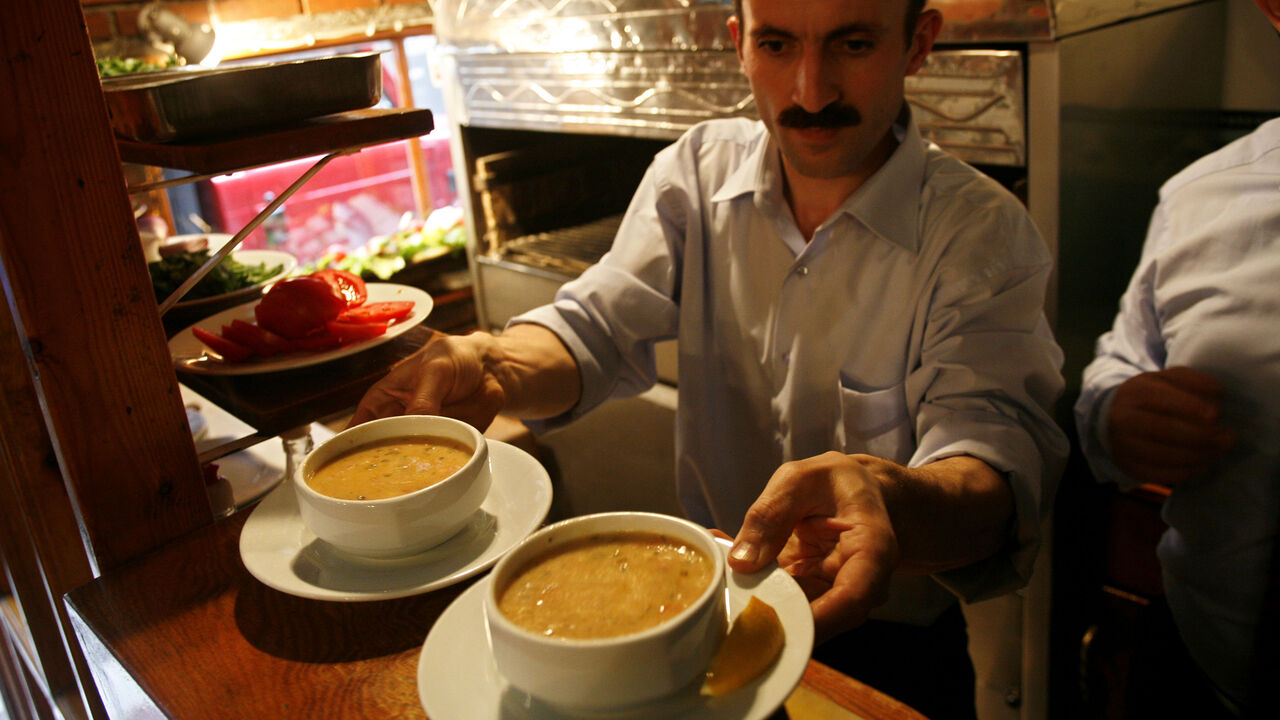 56005712YL016_tour ISTANBUL, TURKEY - SEPTEMBER 28: Balik Lokantasi restaurant's kitchen chief serves fish soup, in Karakoy district on September 28, 2006 in Istanbul, Turkey. Balik Lokantasi means Fish Restaurant in Turkish, as its name, it is a unequally fresh fish plates comes from the see or the Bosporus every day. its owner, Mr. Ozkaraman mentions that he doesn't have a refrigerator, when the fresh fish are finished he closes up the restaurant. (Photo by Yoray Liberman/Getty Images)