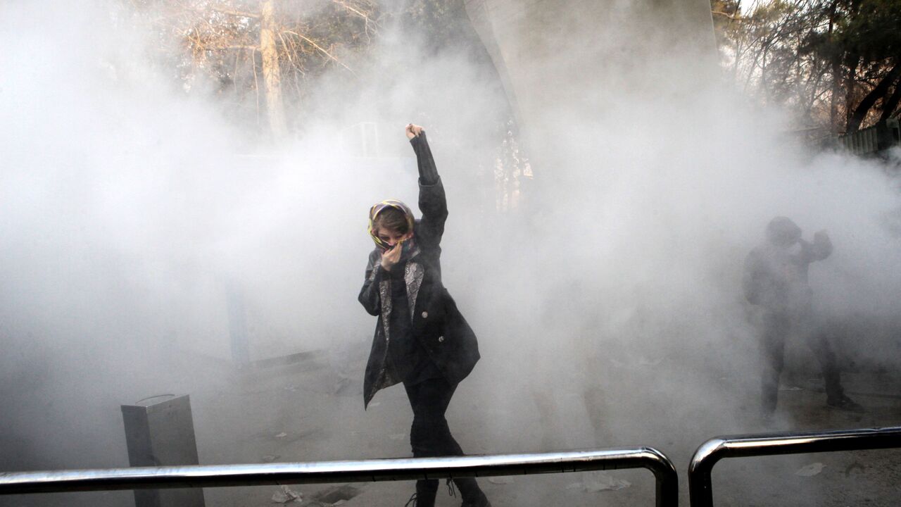 TOPSHOT-IRAN-POLITICS-DEMO TOPSHOT - An Iranian woman raises her fist amid the smoke of tear gas at the University of Tehran during a protest driven by anger over economic problems, in the capital Tehran on December 30, 2017.
Students protested in a third day of demonstrations sparked by anger over Iran's economic problems, videos on social media showed, but were outnumbered by counter-demonstrators. / AFP PHOTO / STR (Photo credit should read STR/AFP/Getty Images)