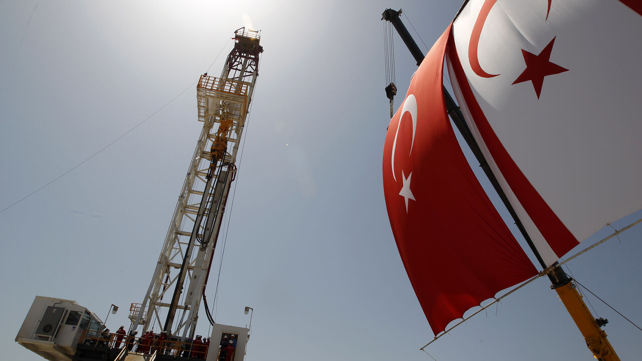 TURKEY-CYPRUS/ Turkish and Turkish Cypriot flags wave next to a drilling tower 25 km (16 miles) from Famagusta April 26, 2012. Turkish Cypriot Leader Dervis Eroglu and Turkey's Energy Minister Taner Yildiz attended a ceremony marking the start of joint gas and oil exploration works in northern Cyprus between Turkey's state-owned energy company TPAO and the Turkish-Cypriot administration. REUTERS/Umit Bektas (CYPRUS - Tags: POLITICS ENERGY BUSINESS) - GM1E84Q1HIQ01