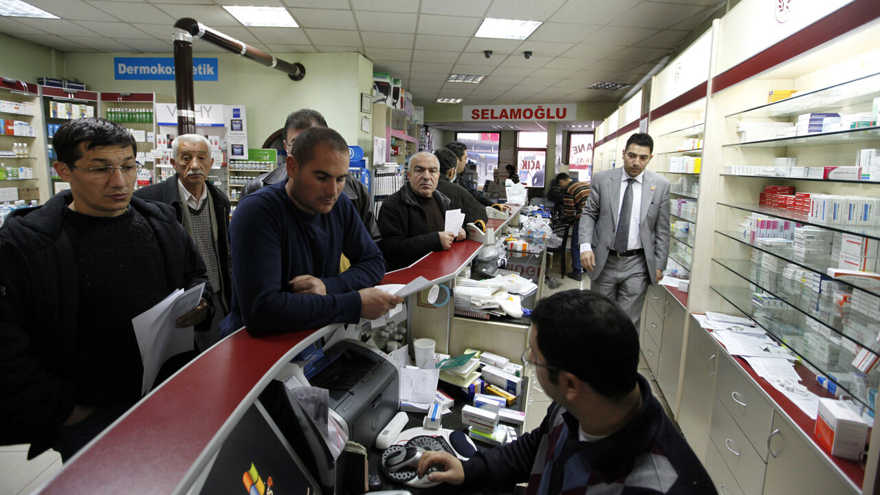 People shop in a pharmacy that did not participate in a  protest in Ankara December 4, 2009. Pharmacies shut down all over Turkey on Friday for one day to protest price discounts on drugs enforced by the government. REUTERS/Umit Bektas (TURKEY POLITICS HEALTH CONFLICT) - GM1E5C41P5H01
