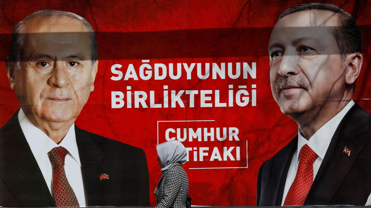 TURKEY-ELECTION/ A woman walks past a banner for the upcoming local elections in Ankara, Turkey, March 27, 2019. Banner with pictures of Turkish President Tayyip Erdogan and Devlet Bahceli, leader of Nationalist Movement Party (MHP), reads: "People's Alliance: The unity of common sense." REUTERS/Umit Bektas - RC14BCF5B7C0