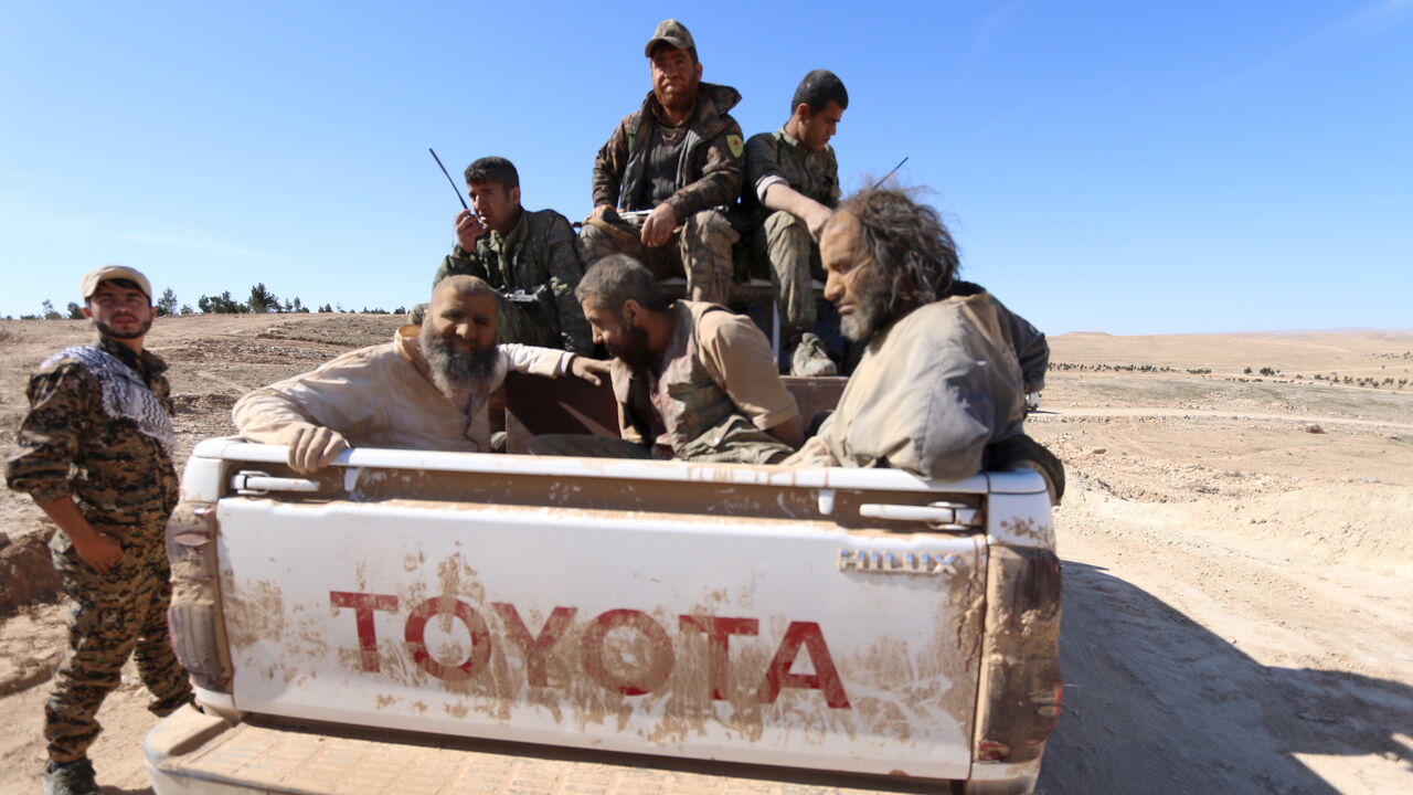 MIDEAST-CRISIS/HASAKA-ISLAMIC-STATE Three men that Democratic Forces of Syria fighters claimed were Islamic State fighters sit on a pick-up truck while being held as prisoners, near al-Shadadi town, Hasaka countryside, Syria, February 18, 2016. REUTERS/Rodi Said - GF10000314445