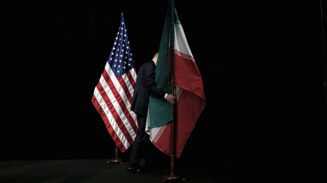 USA-ELECTION/IRAN A staff member removes the Iranian flag from the stage after a group picture with foreign ministers and representatives of the U.S., Iran, China, Russia, Britain, Germany, France and the European Union during the Iran nuclear talks at the Vienna International Center in Vienna, Austria July 14, 2015. To match Analysis USA-ELECTION/IRAN REUTERS/Carlos Barria/File Photo - S1AEULVWJEAA