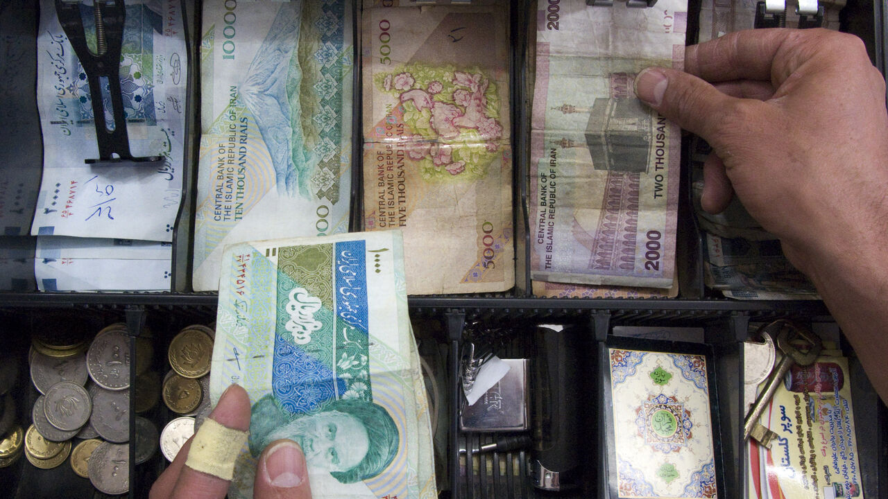WITNESS-IRAN-SANCTIONS/BANK A storekeeper places money in the drawer of the cash register at his shop in Tehran May 4, 2008. With Western banks cutting ties with the Islamic Republic, it is becoming more and more difficult to transfer funds to the country of 70 million people. Tehran's increasing financial isolation is forcing some to bring in money by hand in thick wads of $100 bills on the plane from Dubai, the Gulf's financial centre, or elsewhere. REUTERS/Morteza Nikoubazl (IRAN) - GM1E4580O5Y01
