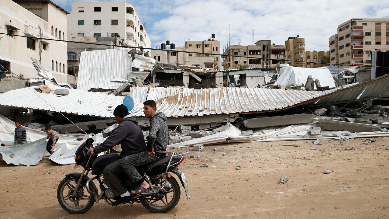 ISRAEL-PALESTINIANS/AIRSTRIKES Palestinians pass near the destroyed Hamas site following Israeli air strikes, in Gaza City March 15, 2019. REUTERS/Mohammed Salem - RC1DEBFDC9E0