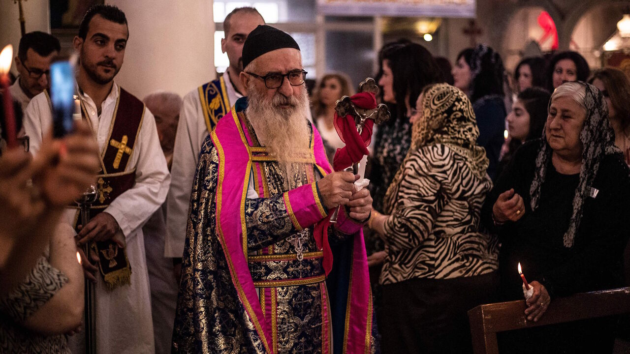 1139833468 A priest blesses worshippers during an Orthodox Easter service at the Church of Saint Jacob in the Kurdish-controlled city of Qamishli in northeastern Syria on April 28, 2019. (Photo by Delil souleiman / AFP) (Photo credit should read DELIL SOULEIMAN/AFP/Getty Images)