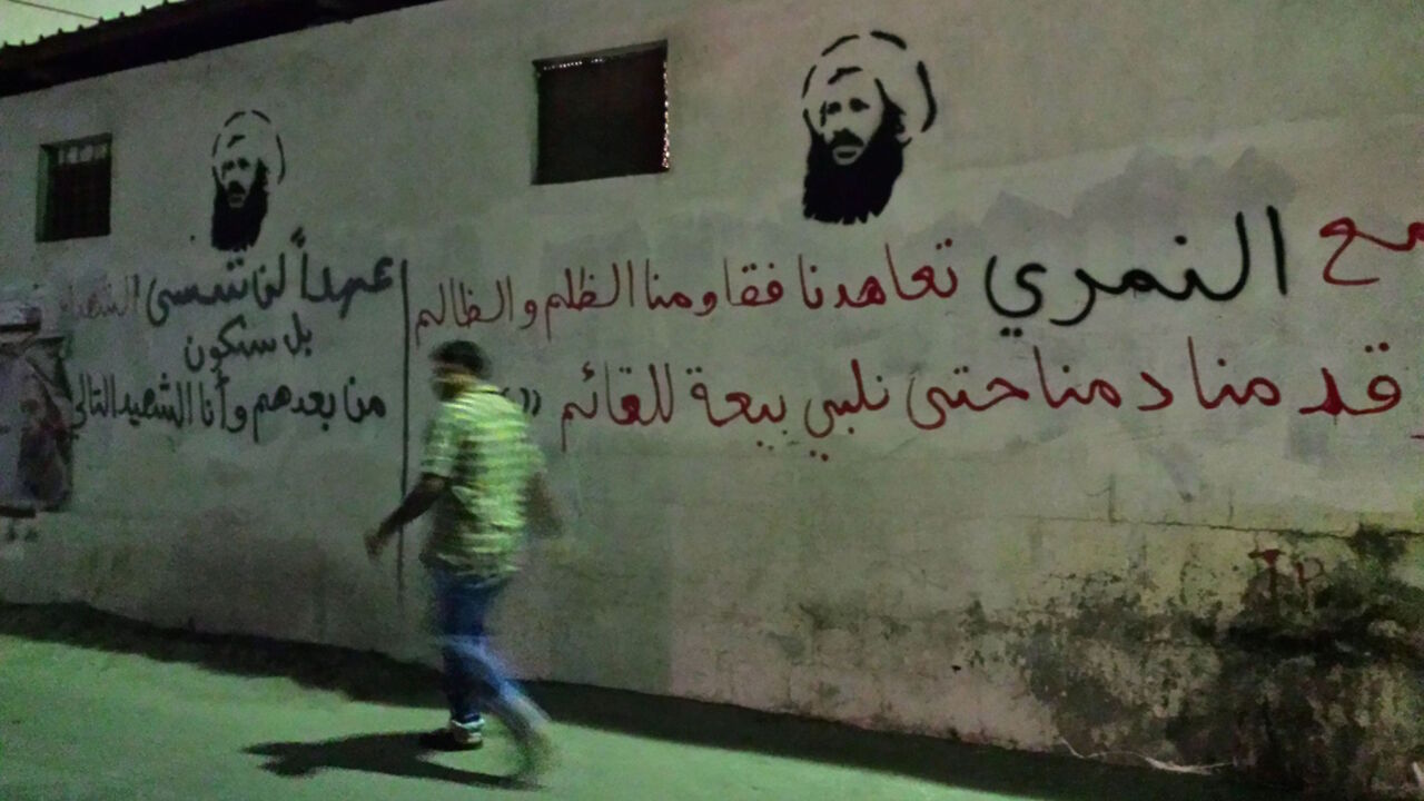 628715684 An undated picture taken in 2016 shows a man walking past images of executed Shiite cleric Nimr al-Nimr on a wall in the Awamiya area in Saudi Arabia's Eastern province.
In a Sunni-majority kingdom where banners of King Salman, his crown prince and deputy crown prince are widely displayed, the homage paid to Nimr is unusual and provocative.
/ AFP / STRINGER (Photo credit should read STRINGER/AFP/Getty Images)