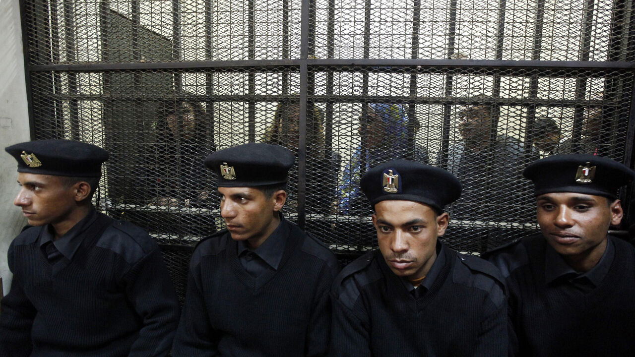 EGYPT Some of the fourteen Egyptian activists who were accused of working for unlicensed non-governmental organizations (NGOs) and receiving illegal foreign funds, stand in a cage during the opening of their trial in Cairo February 26, 2012. An Egyptian court adjourned the trial of dozens of democracy activists including 16 Americans on Sunday at the opening session of a case that has threatened ties between Cairo and Washington and $1.3 billion in annual U.S. military aid. REUTERS/Mohamed Abd El Ghany (EGYPT -
