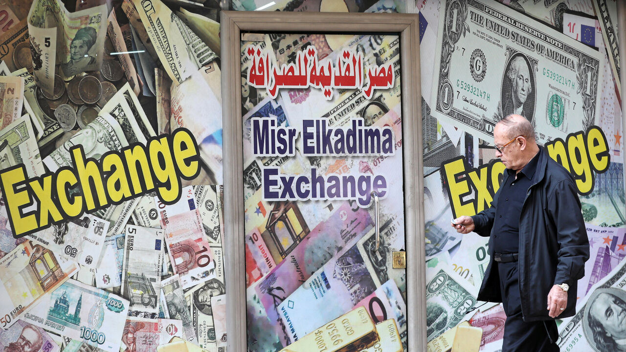 A man walks past a currency exchange bureau advertisement showing images of the U.S. dollar and other currencies in Cairo A man walks past a currency exchange bureau advertisement showing images of the U.S. dollar and other currencies in Cairo, Egypt, April 2, 2019. REUTERS/Mohamed Abd El Ghany - RC1BF9442E80