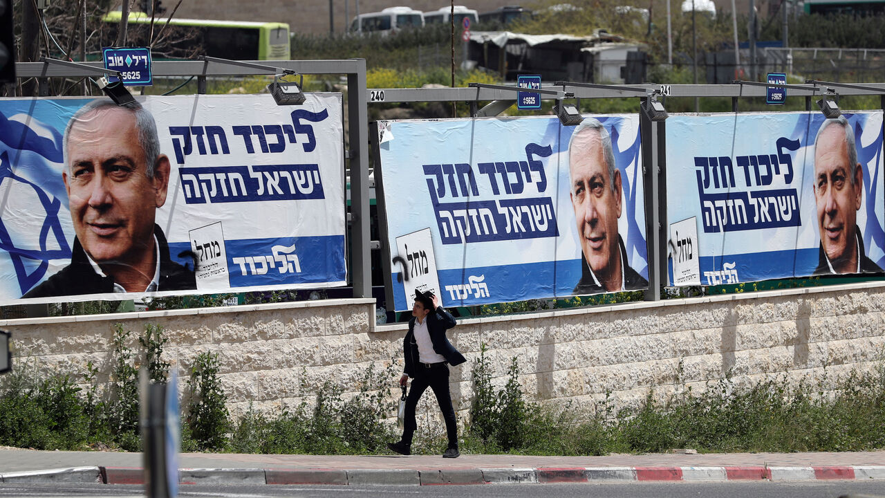 ISRAEL-ELECTION/POSTERS An ultra-Orthodox Jewish man walks past a Likud election campaign poster depicting Israeli Prime Minister Benjamin Netanyahu in Jerusalem April 7, 2019. REUTERS/Ammar Awad - RC1CC13589E0
