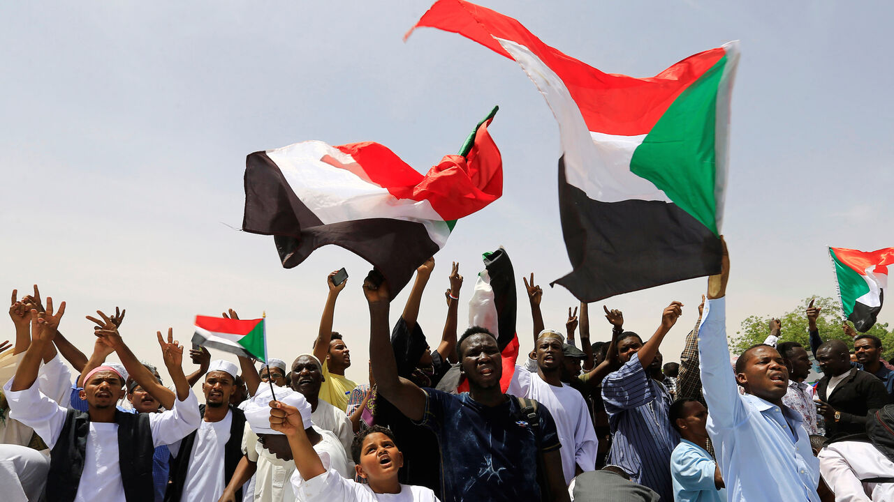 SUDAN-POLITICS/ Sudanese demonstrators wave their national flags and chants slogans as they protest against the army's announcement that President Omar al-Bashir would be replaced by a military-led transitional council, near Defence Ministry in Khartoum, Sudan April 12, 2019. REUTERS/Stringer - RC11244C6310