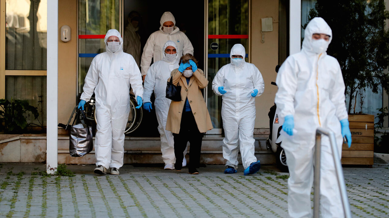 Paramedics escort a woman as she walks toward an ambulance during a two-day curfew which was imposed to prevent the spread of the coronavirus disease (COVID-19), in Istanbul, Turkey, April 12, 2020. REUTERS/Umit Bektas - RC263G9BX0NW
