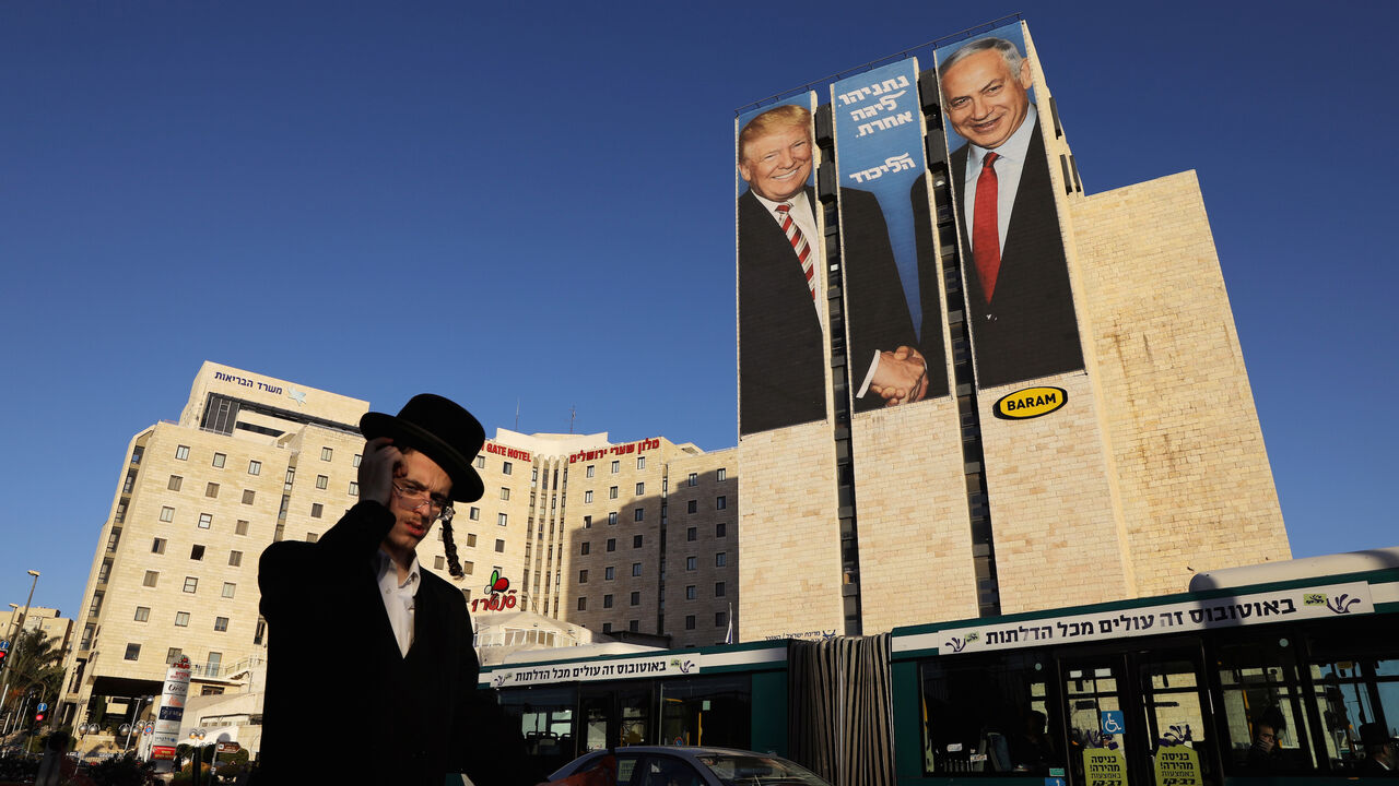 ISRAEL-ELECTION/TRUMP A man walks past a Likud election campaign billboard, depicting U.S. President Donald Trump shaking hands with Israeli Prime Minister Benjamin Netanyahu, in Jerusalem February 4, 2019. REUTERS/Ammar Awad - RC1275660830