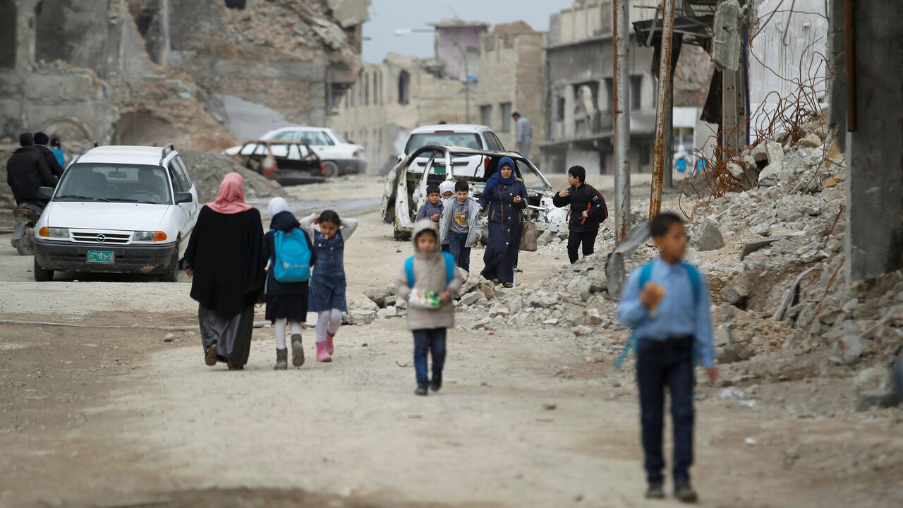 IRAQ-DAILYLIFE/ Iraqi school students pass by destroyed buildings by the war, in the Old City of Mosul, Iraq February 27, 2019. REUTERS/Khalid al-Mousily - RC1D1A58CF70