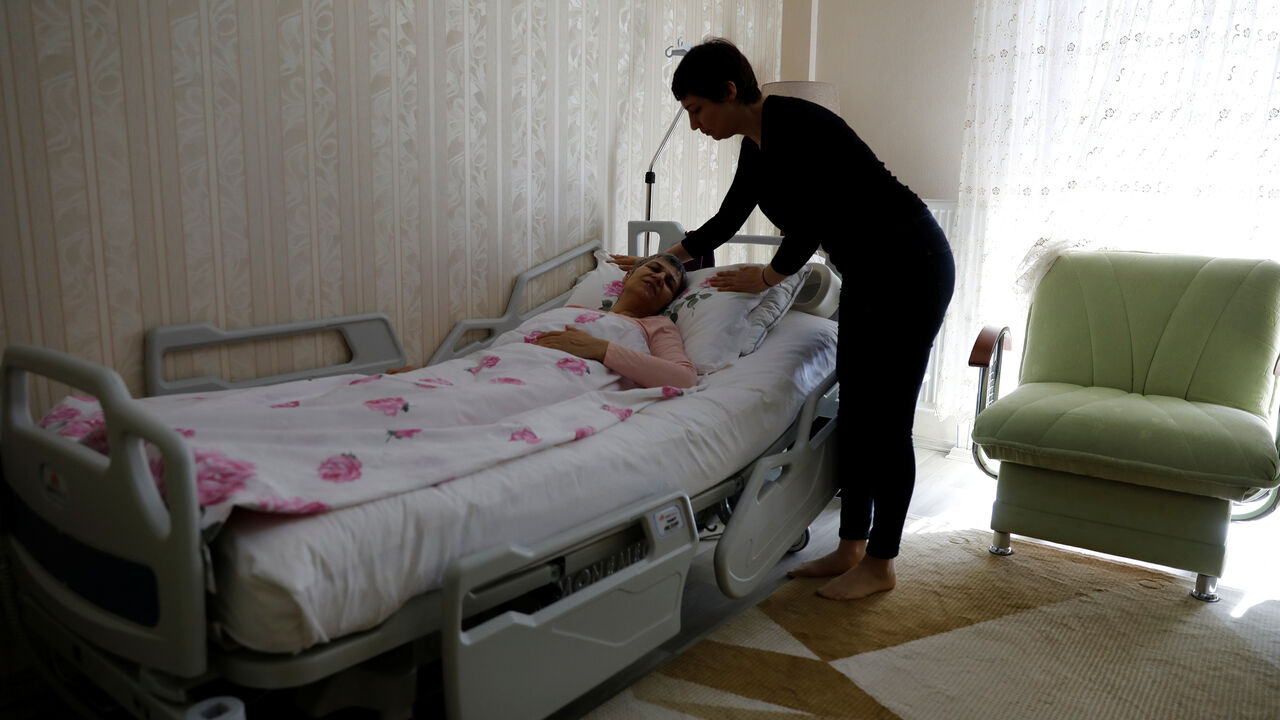 TURKEY-ELECTION/KURDS Sabiha Temizkan, daughter of pro-Kurdish Peoples' Democratic Party (HDP) lawmaker Leyla Guven, who has been on a hunger strike for more than four months, adjusts her mother's pillow at their home in Diyarbakir, Turkey, March 20, 2019. Picture taken March 20, 2019. REUTERS/Umit Bektas - RC1E573D6D20