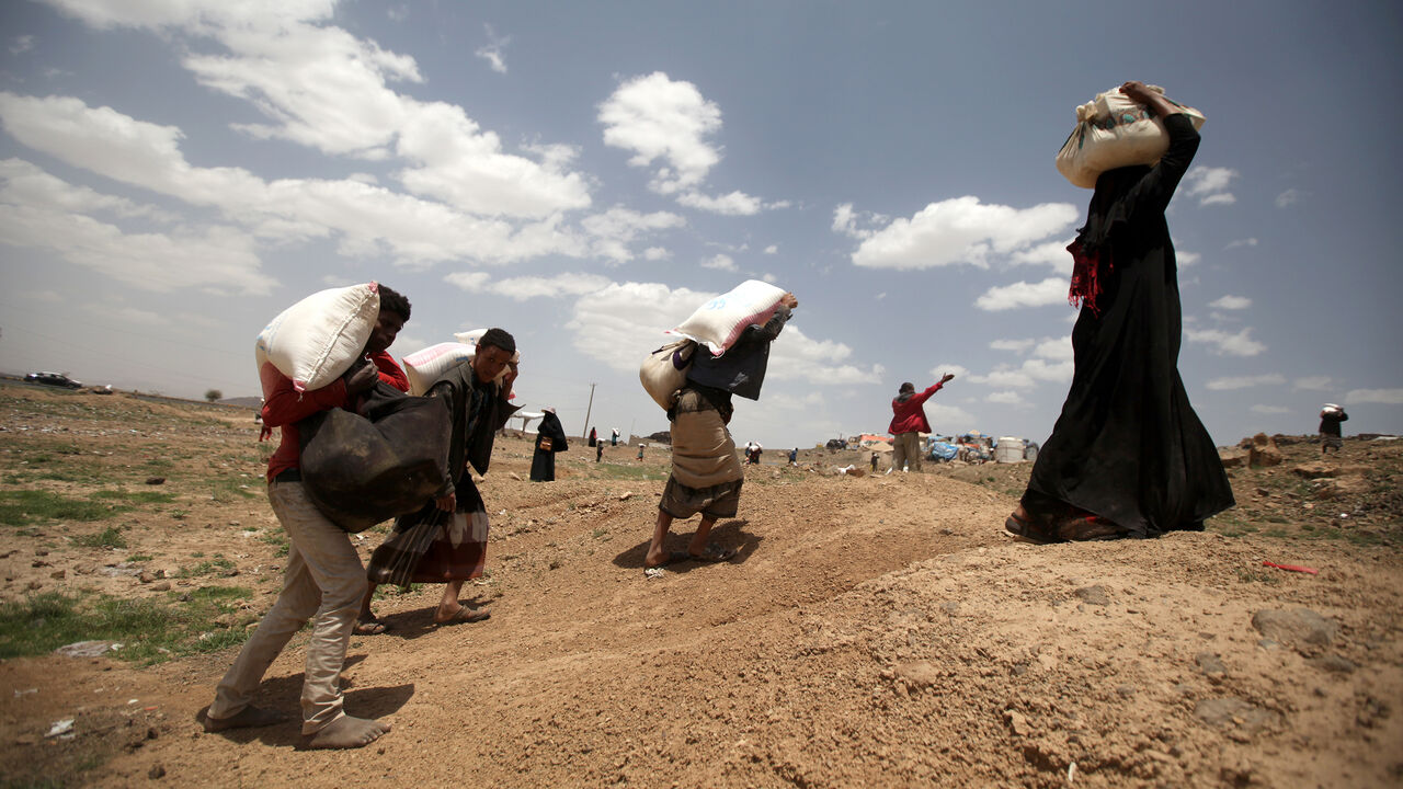 People carry food aid they received from the local charity, Mona Relief, ahead of the holy month of Ramadan on the outskirts of Sanaa, Yemen May 5, 2019. REUTERS/Khaled Abdullah - RC130ADB5390