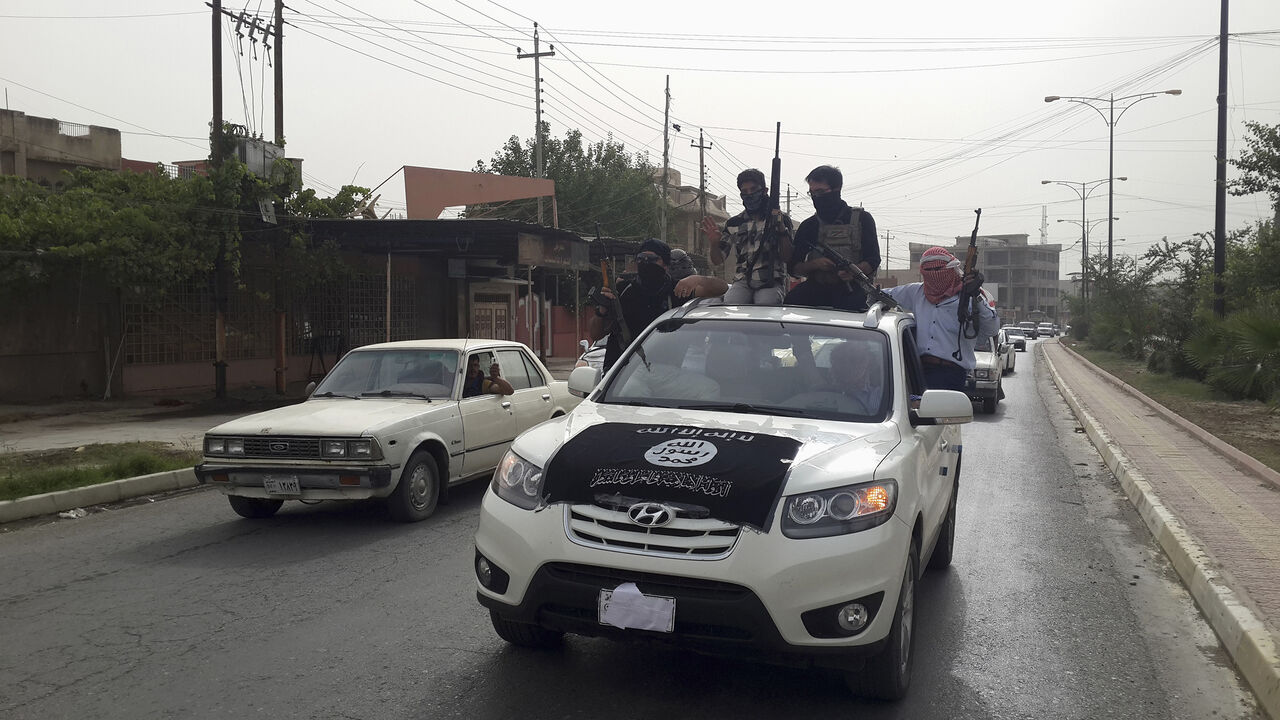 IRAQ-SECURITY/ Fighters of the Islamic State of Iraq and the Levant (ISIL) celebrate on vehicles taken from Iraqi security forces, at a street in city of Mosul, June 12, 2014. Since Tuesday, black clad ISIL fighters have seized Iraq's second biggest city Mosul and Tikrit, home town of former dictator Saddam Hussein, as well as other towns and cities north of Baghdad. They continued their lightning advance on Thursday, moving into towns just an hour's drive from the capital. Picture taken June 12, 2014. REUTERS/Stringer (I