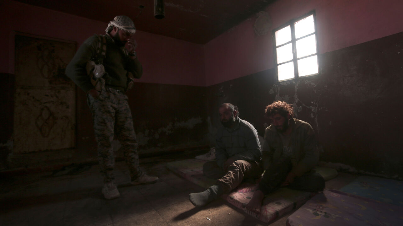 MIDEAST-CRISIS/SYRIA A Syrian Democratic Forces (SDF) fighter stands near who he said were Islamic State fighters held prisoners, north of Raqqa city, Syria March 8, 2017. REUTERS/Rodi Said TPX IMAGES OF THE DAY - RC15149E3320