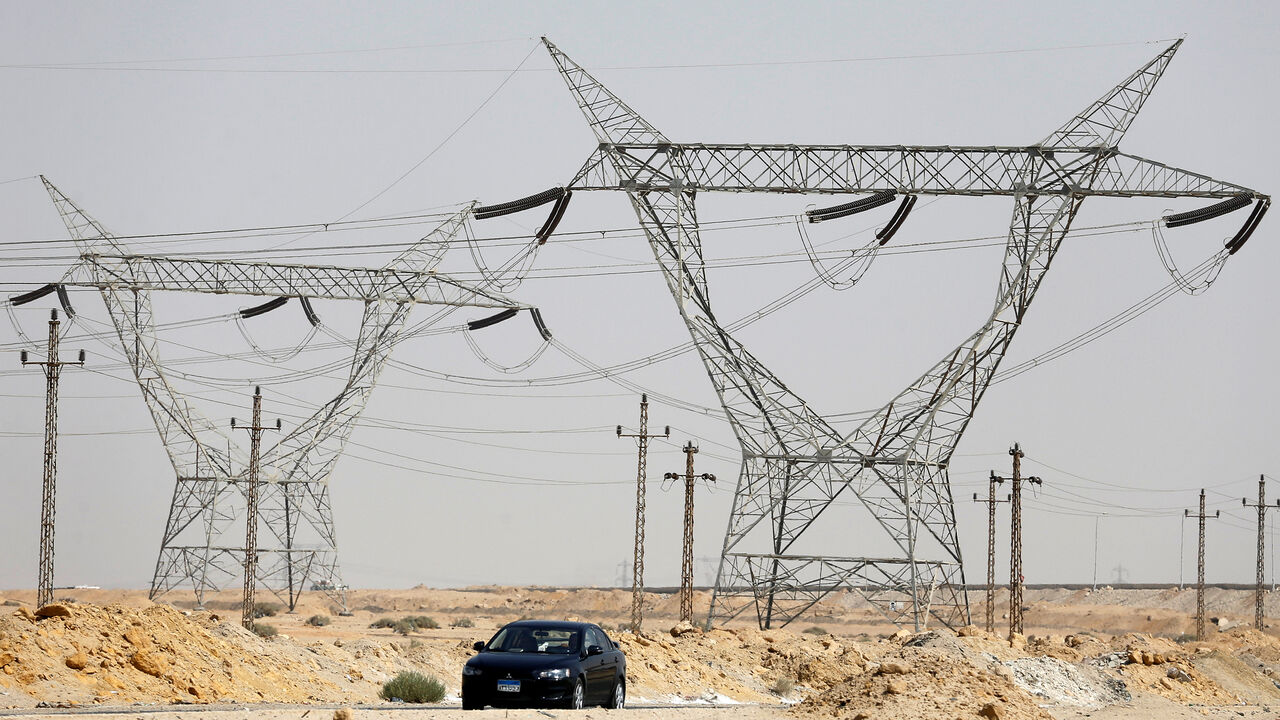 GLOBAL-ENERGY/ A car passes power lines connecting pylons of high-tension electricity at the highway in Cairo, Egypt August 14, 2017. REUTERS/Amr Abdallah Dalsh - RC122337A6E0