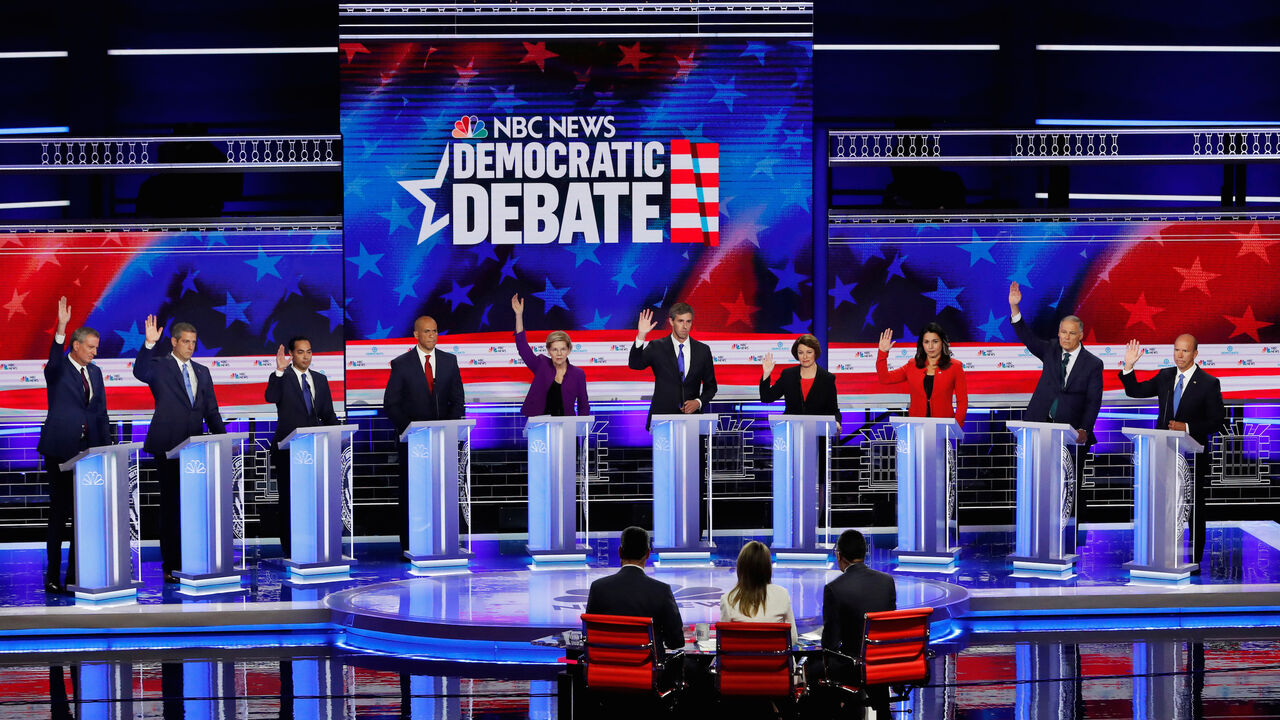 USA-ELECTION/DEBATE All candidates except U.S. Senator Cory Booker raise their hands while responding to a question that they would currently support the original Iran nuclear agreement during the first U.S. 2020 presidential election Democratic candidates debate in Miami, Florida, U.S., June 26, 2019. REUTERS/Mike Segar TPX IMAGES OF THE DAY - HP1EF6R065EGH