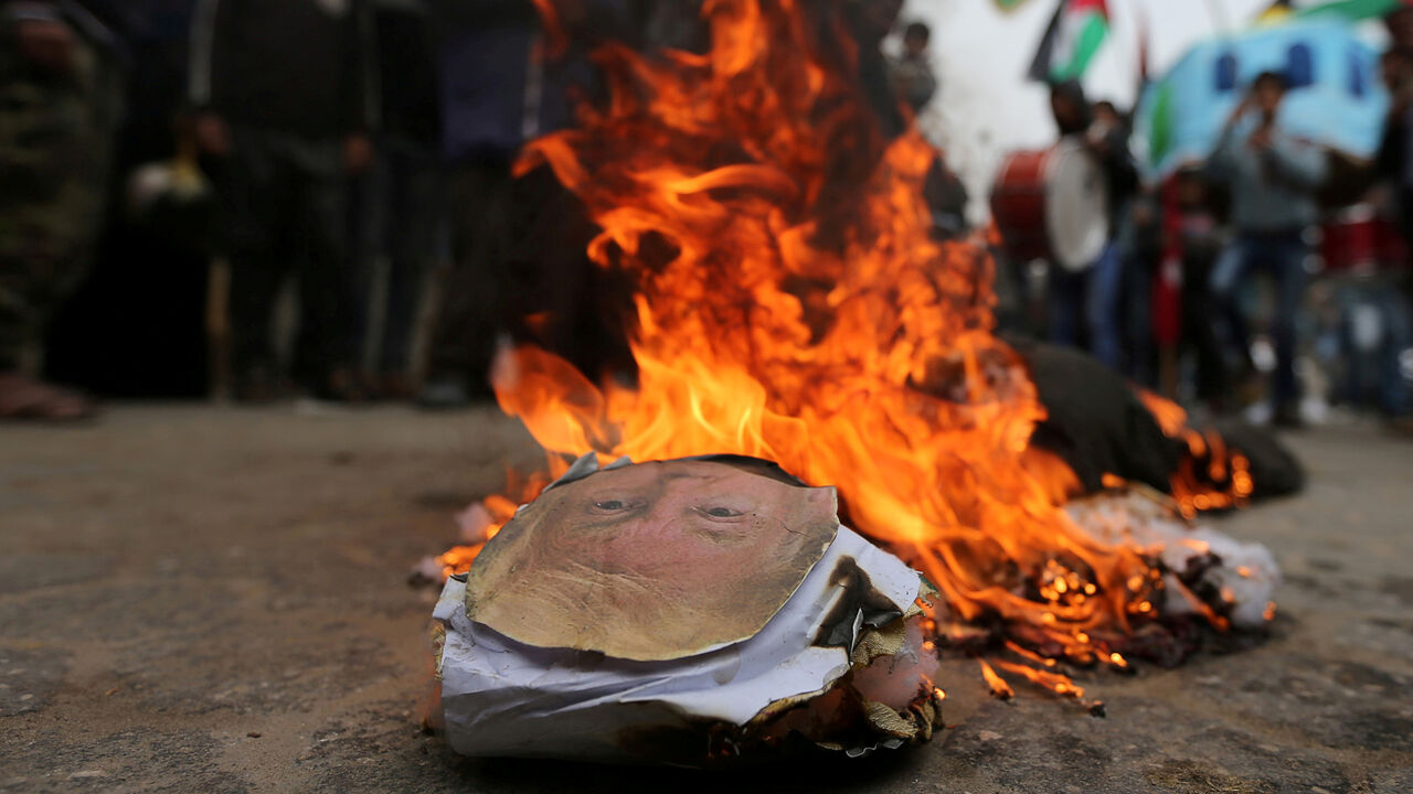 ISRAEL-PALESTINIANS/USA-UN Palestinian demonstrators burn an effigy depicting U.S. President Donald Trump during a protest against U.S aid cuts, outside the United Nations' offices in the southern Gaza Strip February 11, 2018. REUTERS/Ibraheem Abu Mustafa TPX IMAGES OF THE DAY - RC1D5F27F630