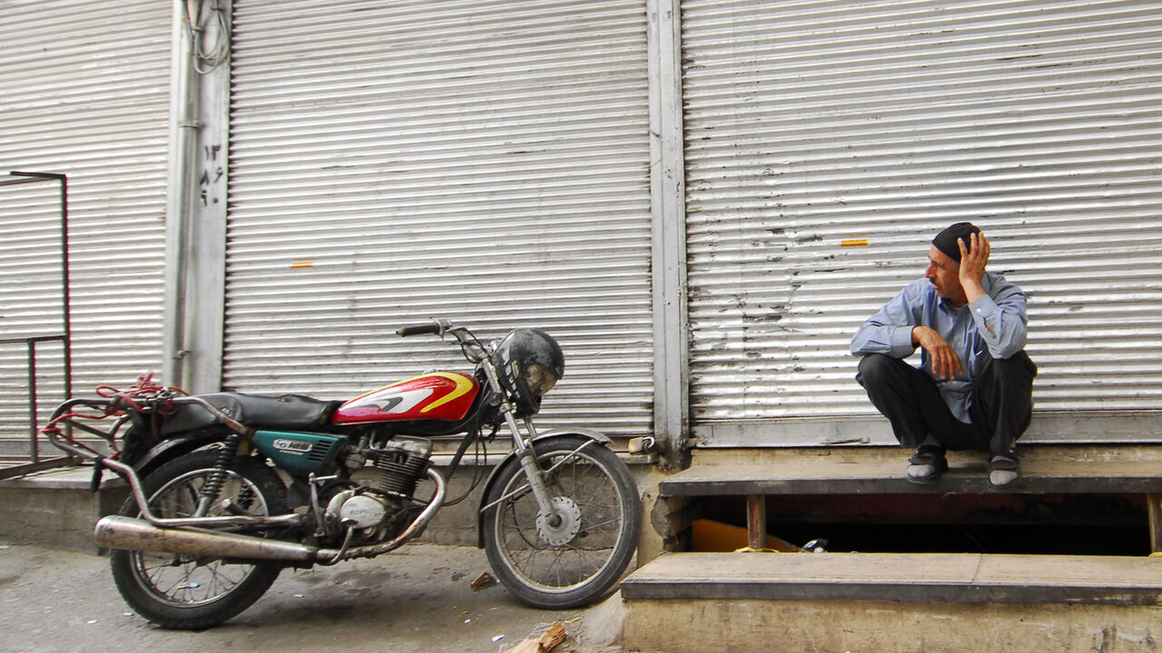 IRAN-STRIKE/TAX A man sits outside a shop, which was closed as part of a strike, in Tehran's main bazaar October 12, 2008. A week-long strike against a new value added tax (VAT) appeared to be spreading in Tehran's bazaar on Sunday, even though the Iranian government suspended the measure for two months, witnesses said on Sunday. REUTERS/Stringer (IRAN) - GM1E4AC1M3W01