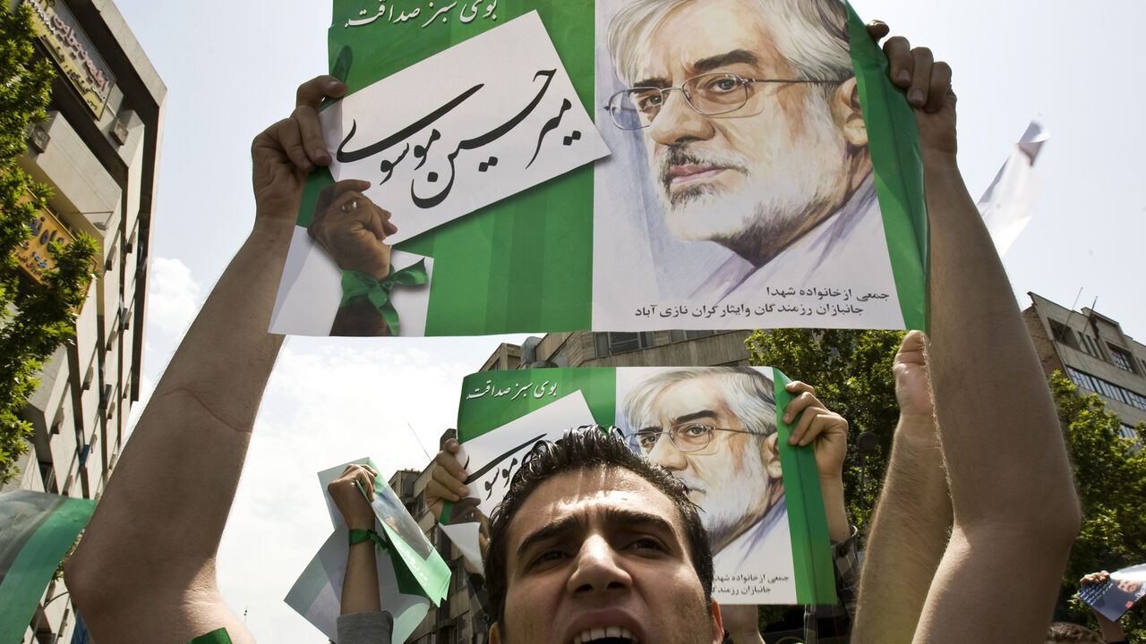 IRAN-ELECTION/ A man holds a poster of Iranian presidential candidate Mir Hossein Mousavi during a rally in support of Mousavi, after Friday prayers in Tehran May 29, 2009. Iranians vote on June 12 in an election that pits hardline President Mahmoud Ahmadinejad against two moderate challengers and one fellow conservative. REUTERS/Raheb Homavandi (IRAN POLITICS ELECTIONS) - GM1E55T1JXM01
